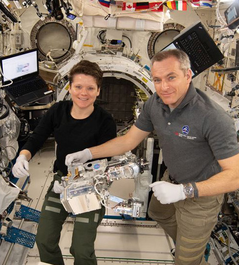 Astronauts Anne McClain and David Saint-Jacques pose with the corresponding RRM3 tools aboard the International Space Station