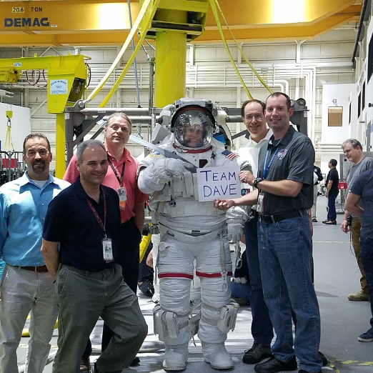 Parker's team holds a sign that reads “Team Dave” in the Neutral Buoyancy Lab, or NBL.